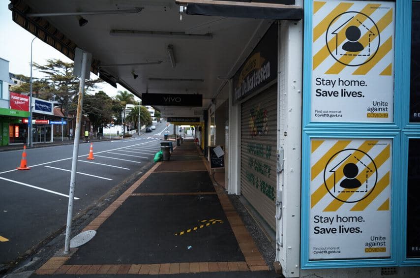 Stay home save lives posters on a billboard and closed shops and empty deserted streets during the coronavirus covid 19 lockdown